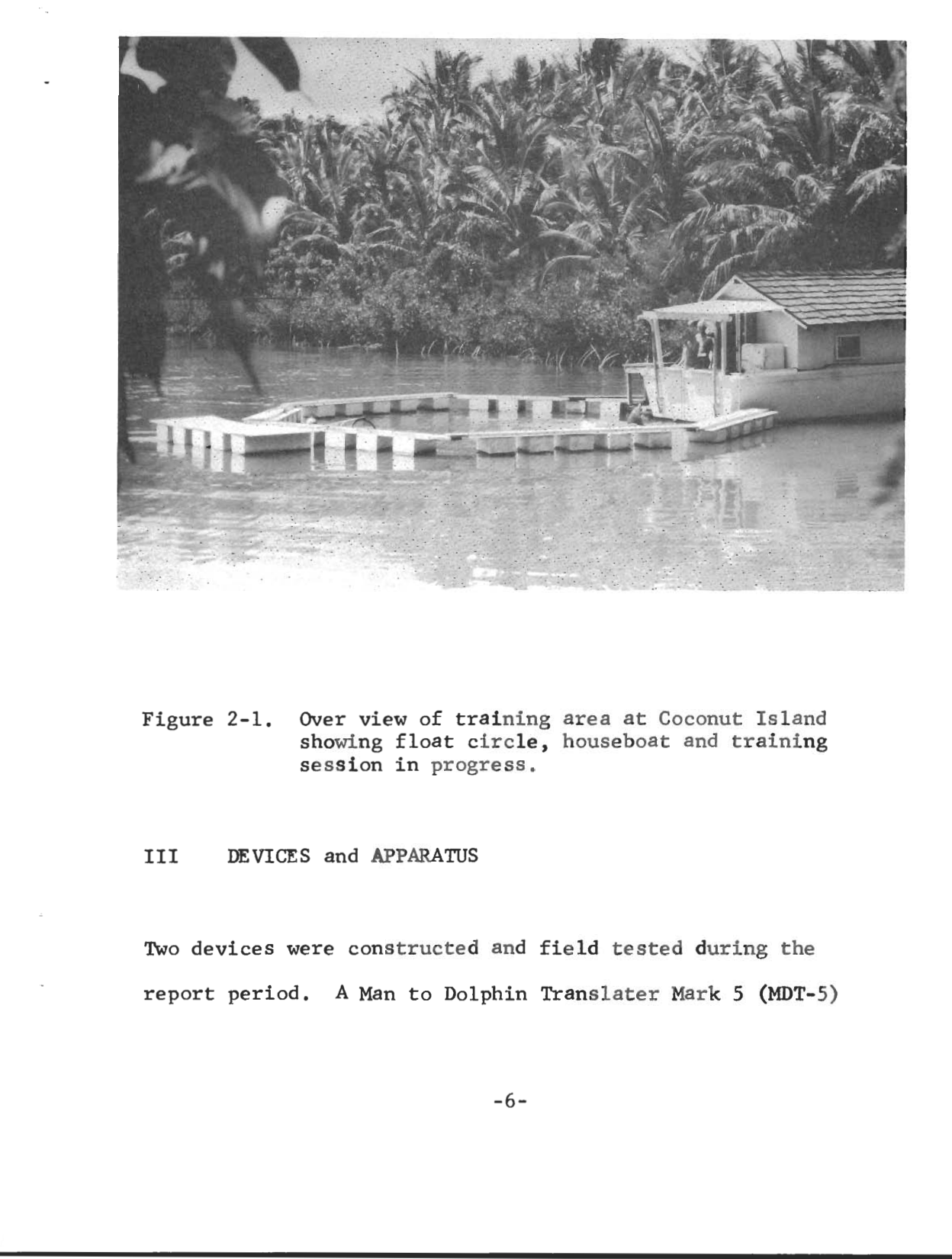 Black and white photograph from the 1967 report showing the training area at Coconut Island: a floating ring of rectangular pontoons in a lagoon, a houseboat at right, dense palms behind.
